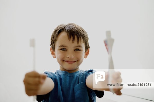 Portrait of a boy holding toothbrush.