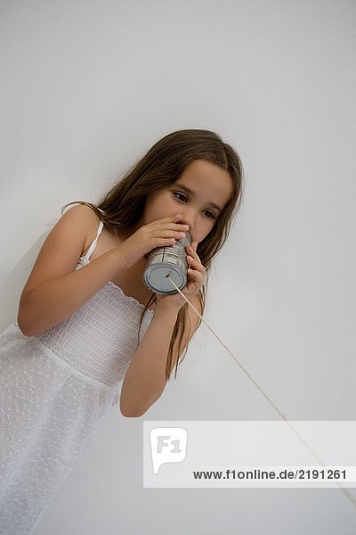 Girl using a tin can as a phone.