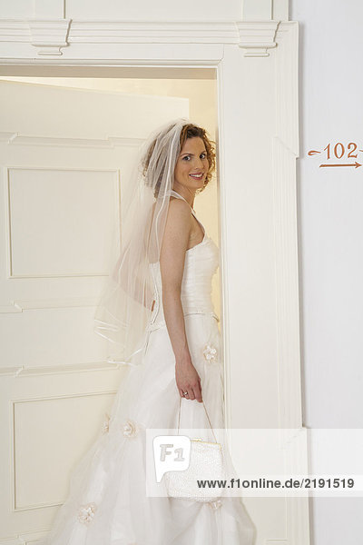 young bride opening door looking over shoulder  portrait