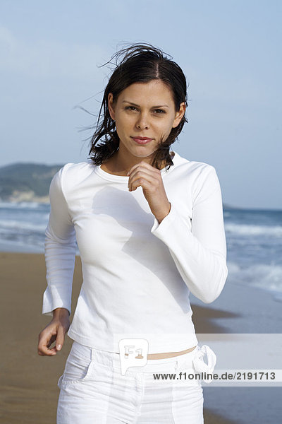 Young woman jogging on beach.