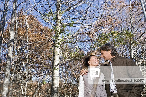 Portrait of a couple surrounded by trees.
