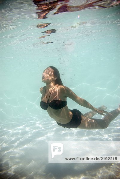 Frau schwimmt unter Wasser