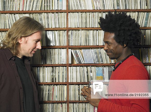 Mann zeigt reifen Mann Compact Disc im Musikgeschäft  lächelnd