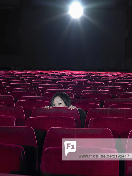Junge Frau beim Blick über den Kinositz