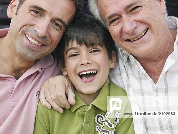 Junge (8-10) sitzend mit Vater und Großvater lächelnd Nahaufnahme Porträt