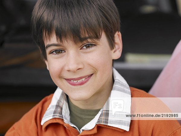 Boy (8-10) with brown eyes and hair smiling close-up portrait