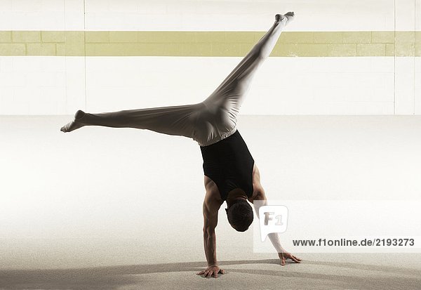 Male gymnast performing floor exercise  rear view