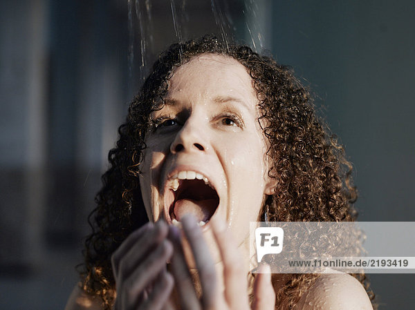 Woman beneath shower  smiling