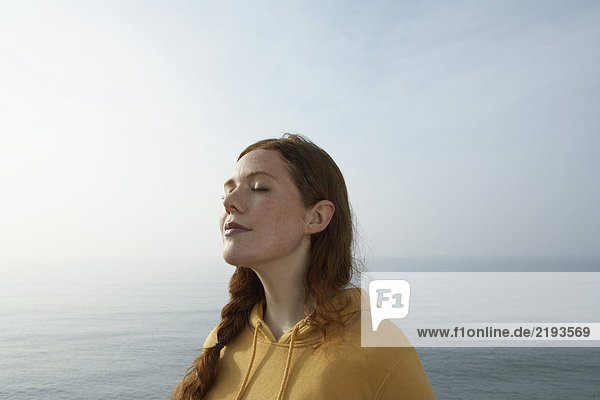 Profile of a young woman by the sea.