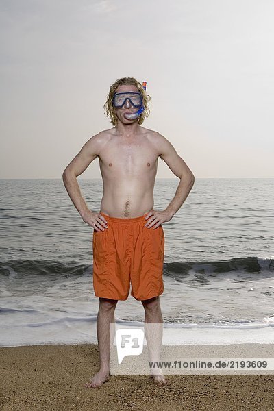 Man wearing mask on beach.