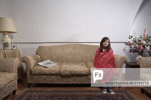 Girl (9-11) sitting on a sofa in a living room  portrait