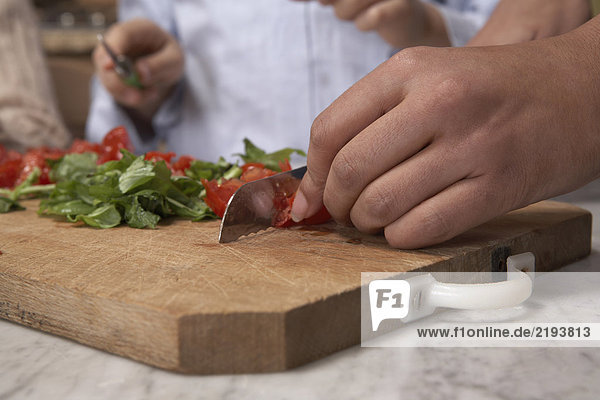 Woman chopping tomato's on board  close-up