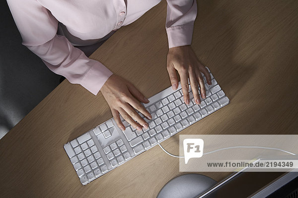 Frauenhände  die auf einer Computertastatur tippen.