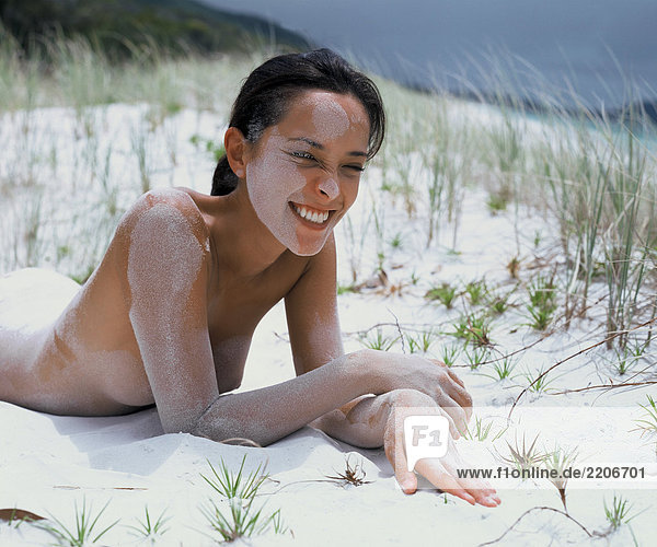 Junge Frau bedeckt mit sand