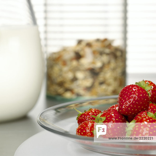 Strawberries on plate  cereals and milk in background