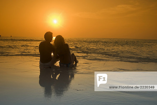 Paar am Strand sitzend  Silhouette bei Sonnenuntergang  Malediven