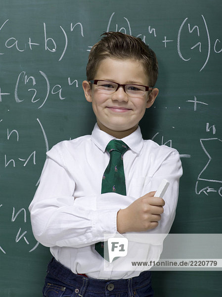 Boy (10-11) leaning against blackboard  smiling  portrait  close-up