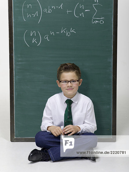 Junge (10-11) sitzend vor Tafel  Portrait