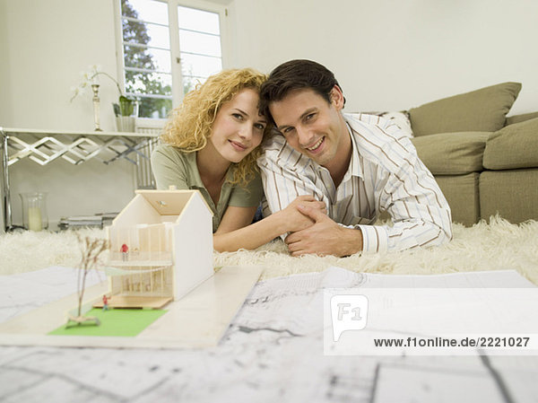 Young couple in living room  smiling  portrait