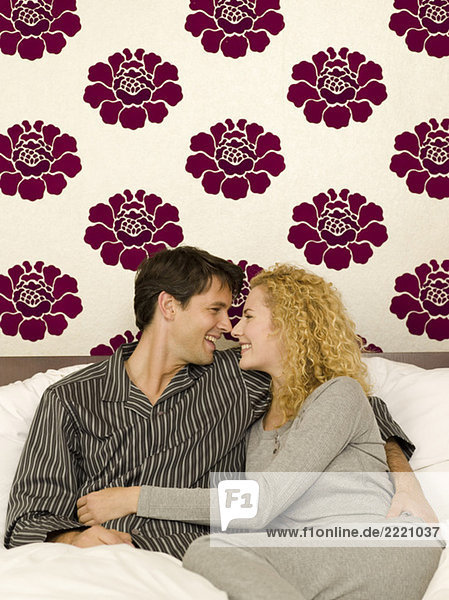 Young couple sitting in bed  portrait