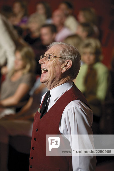 Senior male theatre usher laughing