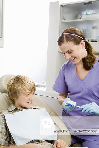 Female dentist showing patient how to brush