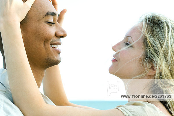 Couple face to face with eyes closed  woman touching man's head