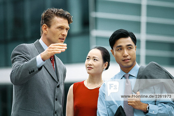 Business associates standing outdoors  talking  man gesturing with hand
