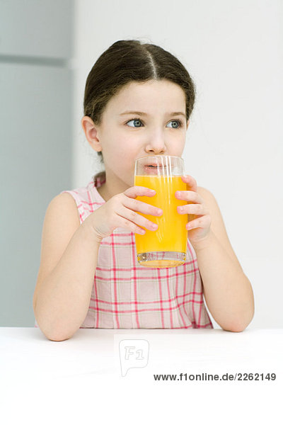 Kleines Mädchen trinkt Orangensaft  schaut weg  Nahaufnahme
