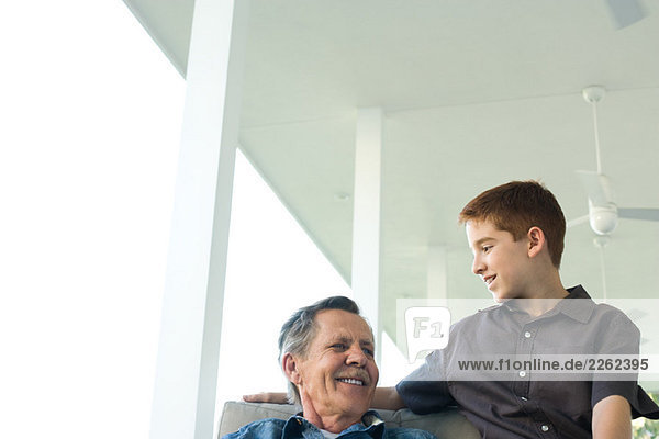 Großvater und Enkel sitzen zusammen auf der Veranda  Blickwinkel niedrig