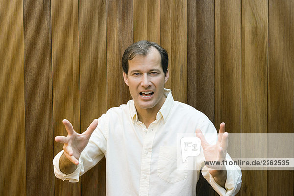 Man gesturing at camera with hands  open mouth