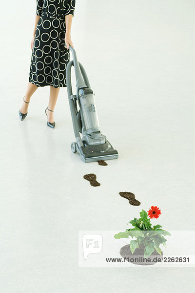 Frau saugt Fußabdrücke des Bodens auf  niedriger Abschnitt