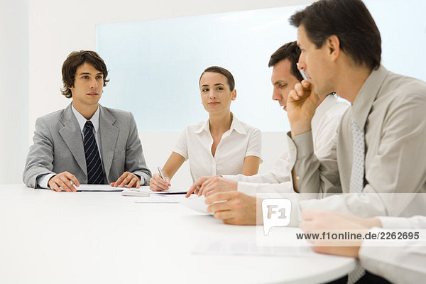 Business associates sitting at table together  having discussion  close-up