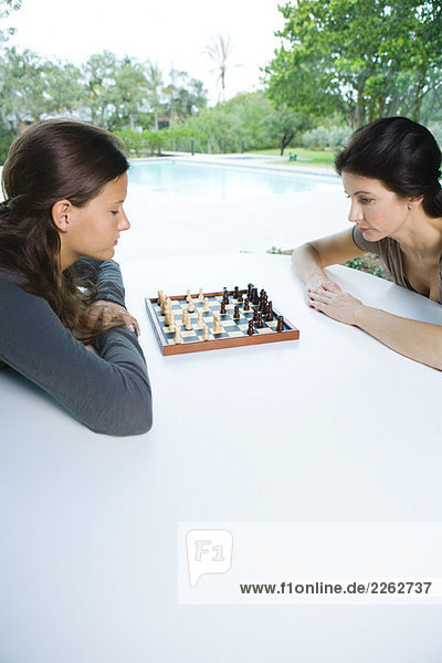Mutter und Tochter beim gemeinsamen Schachspiel im Freien  Seitenansicht