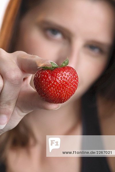 Junge Frau mit einer Erdbeere