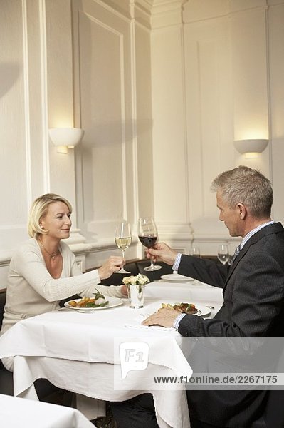Married couple raising glasses of wine during a meal