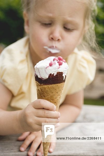 Kleines Mädchen isst Eistüte