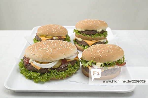 Vier Cheeseburger auf Tablett
