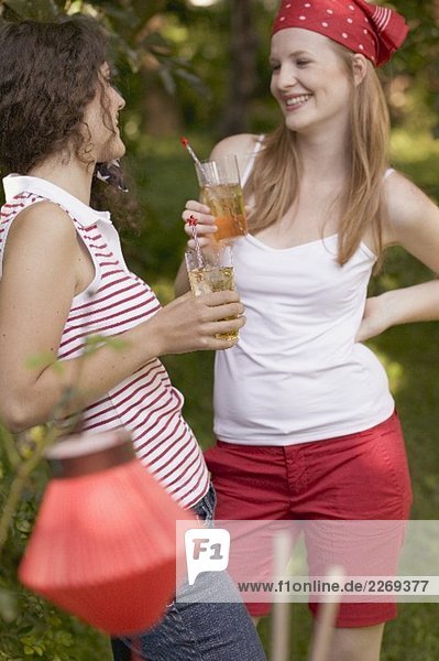 Zwei junge Frauen trinken Eistee am 4th of July (USA)