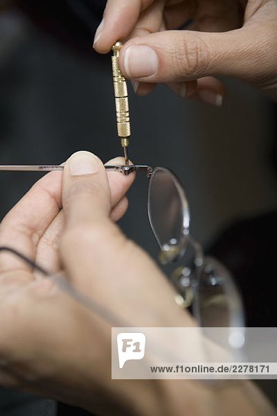 Close up of hands repairing glasses