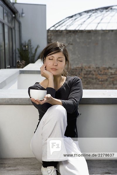 Eine junge Frau entspannt sich auf einem Dachgarten