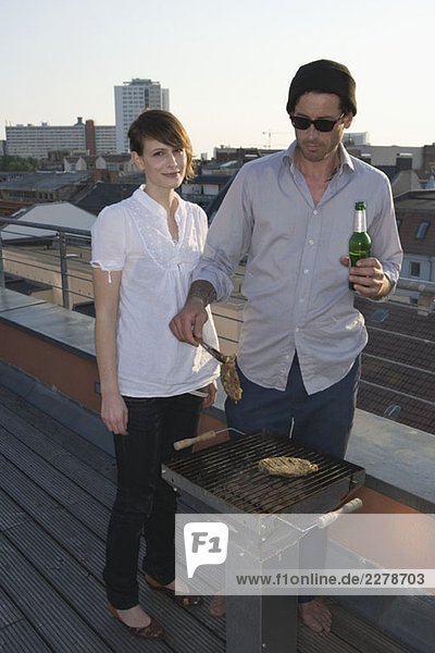 Zwei Personen beim Grillen auf der Dachterrasse