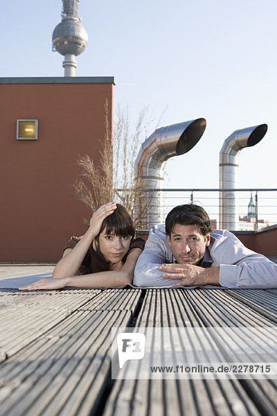 Porträt eines Mannes und einer Frau  die zusammen auf einer Dachterrasse liegen.