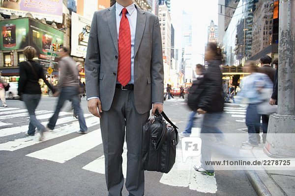 A businessman standing by a pedestrian crossing