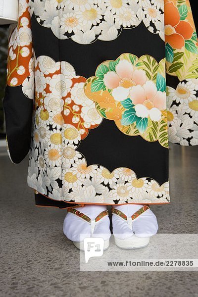 Unterteil einer Frau mit Kimono und Sandalen