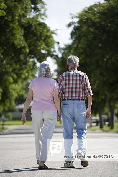 A senior couple walking along a street