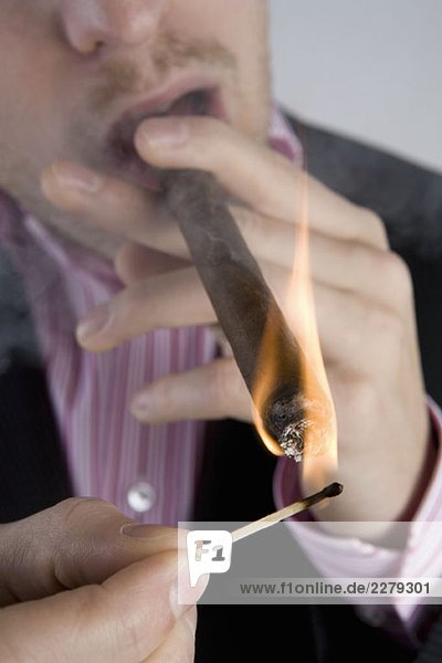 A businessman lighting a cigar