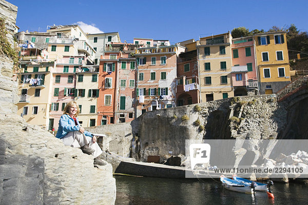 Italy  Liguria  Riomaggiore  Woman sitting on rock