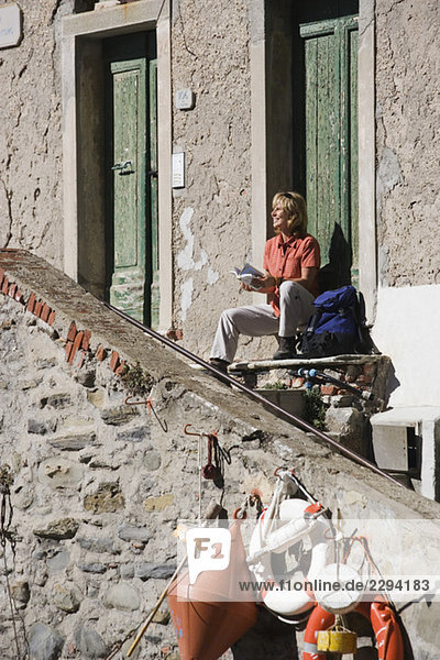 Italien  Ligurien  Riomaggiore  Frau auf einer Treppe sitzend
