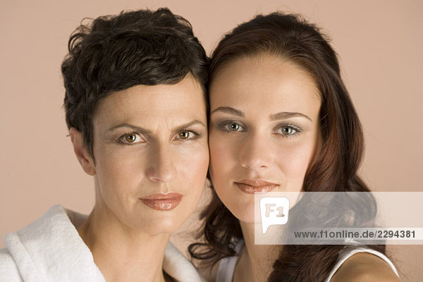 Mature mother and daughter heads together  close up  portrait